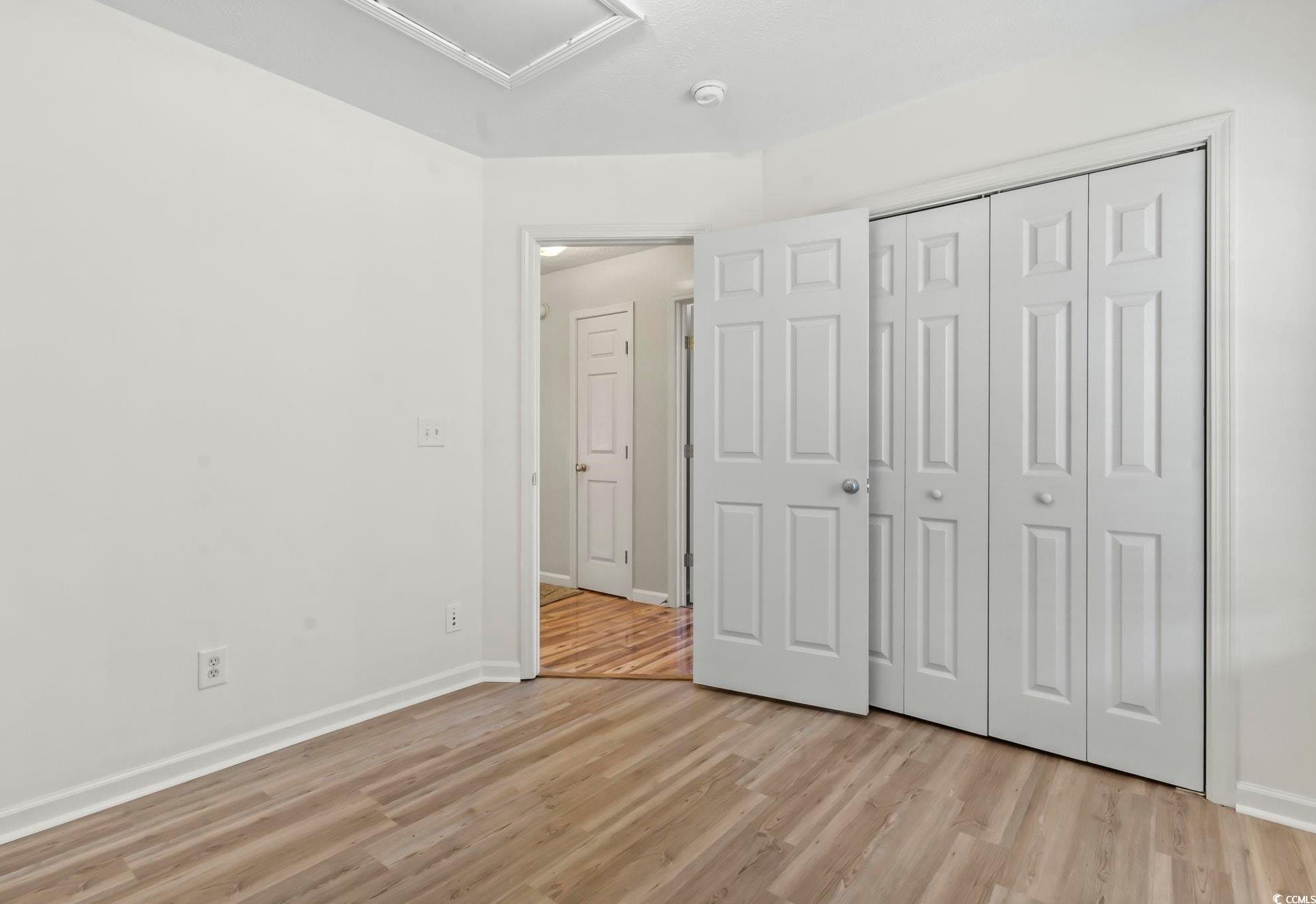 717 West Perry Road Myrtle Beach, SC 29579 - Photo 21 of 29 Unfurnished bedroom with light wood-style floors and a closet