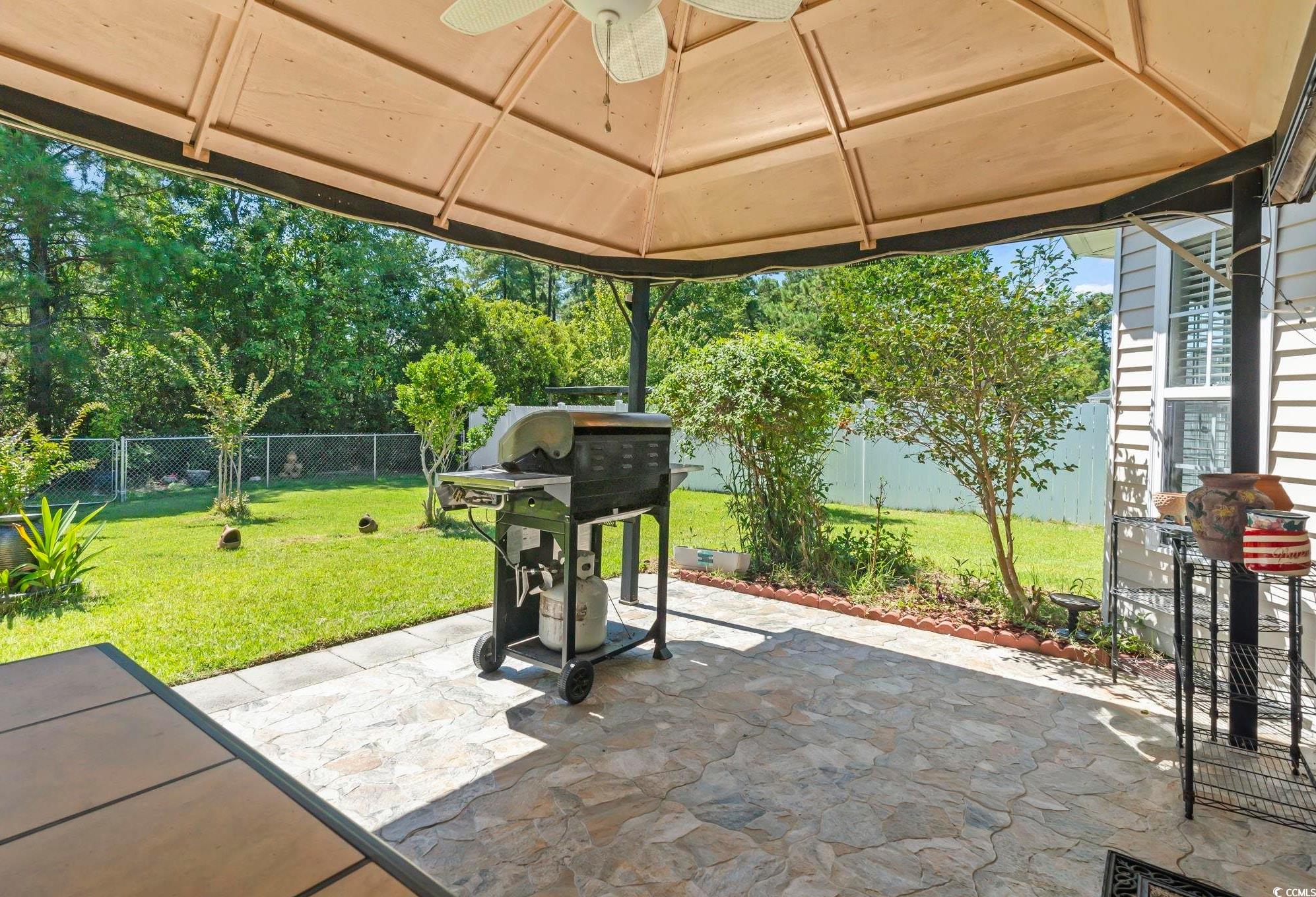717 West Perry Road Myrtle Beach, SC 29579 - Photo 25 of 29 Fenced backyard with a tiled patio, a grill, a gazebo, and a ceiling fan