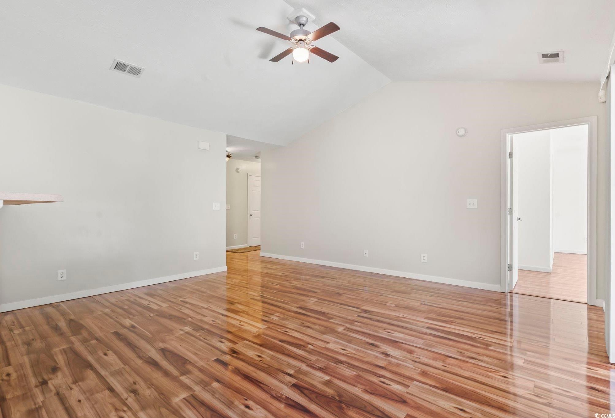717 West Perry Road Myrtle Beach, SC 29579 - Photo 8 of 29 Unfurnished living room featuring light wood finished floors, vaulted ceiling, and a ceiling fan