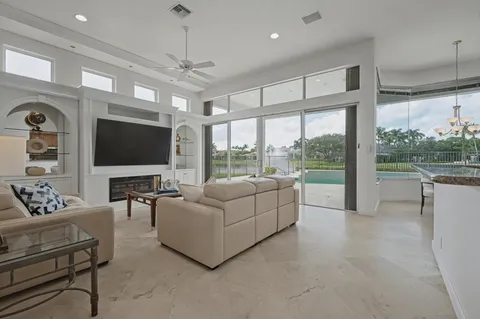 a living room with furniture a flat screen tv and a large window