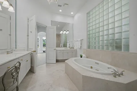 a bathroom with a bathtub and a double vanity sink mirror