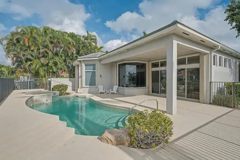 a view of a house with backyard patio and swimming pool