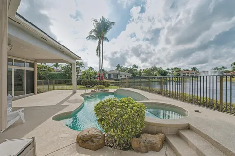 a view of a swimming pool with a patio and a yard