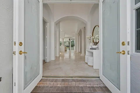 a view of a hallway with wooden floor and a living room