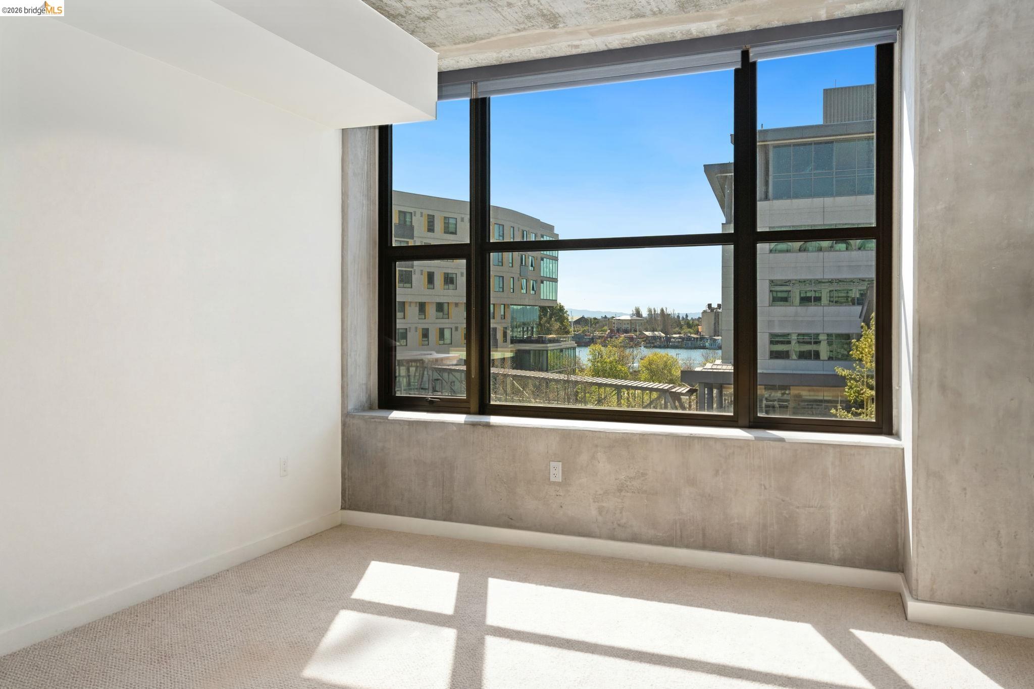 311 2nd Street, Unit 511 Oakland, CA 94607 - Photo 27 of 44 Empty room featuring light colored carpet, healthy amount of natural light, and a view of city