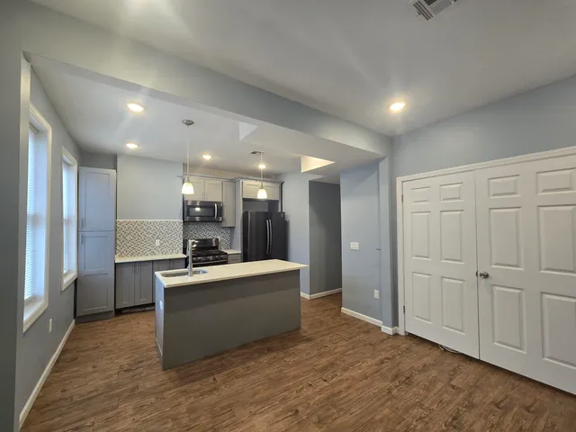 a large white kitchen with a refrigerator a stove top oven a sink and dishwasher