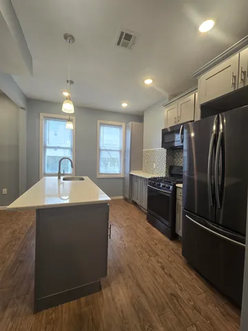 a kitchen with kitchen island a counter top space stainless steel appliances and a window