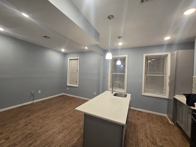 a view of a kitchen with a sink a refrigerator and wooden floor