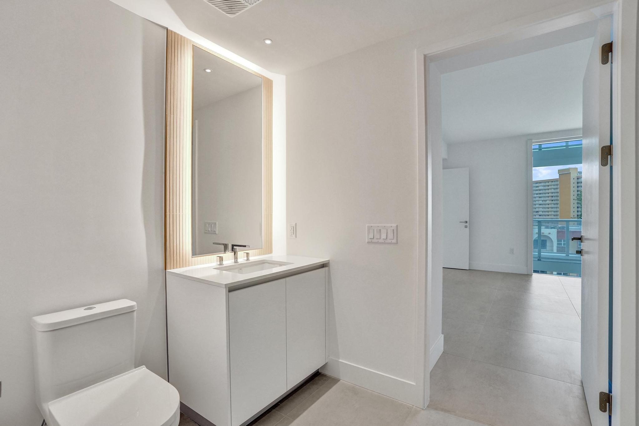 407 North Riverside Drive, Unit 602 Pompano Beach, FL 33062 - Photo 36 of 83 a bathroom with a toilet sink and mirror