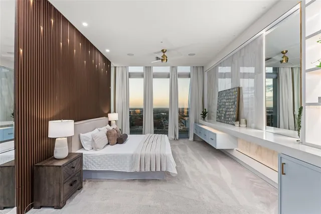 a spacious bedroom with a large bed and a large window