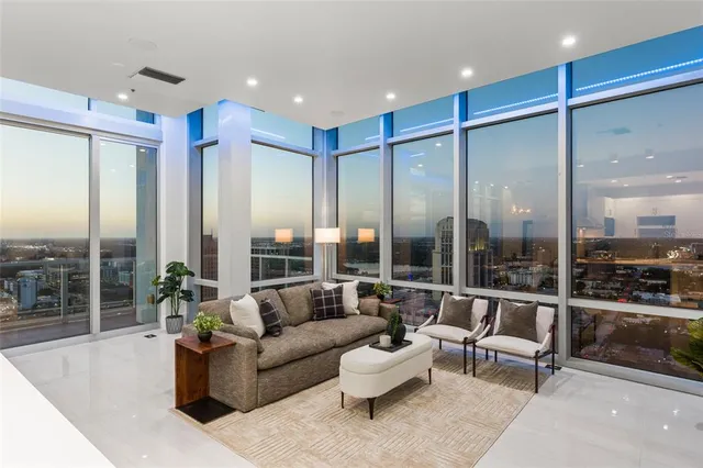 a living room with furniture and a floor to ceiling window