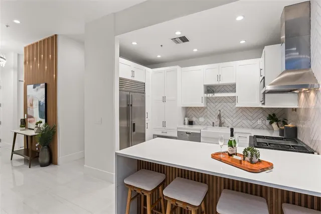a kitchen with stainless steel appliances granite countertop a sink and a refrigerator