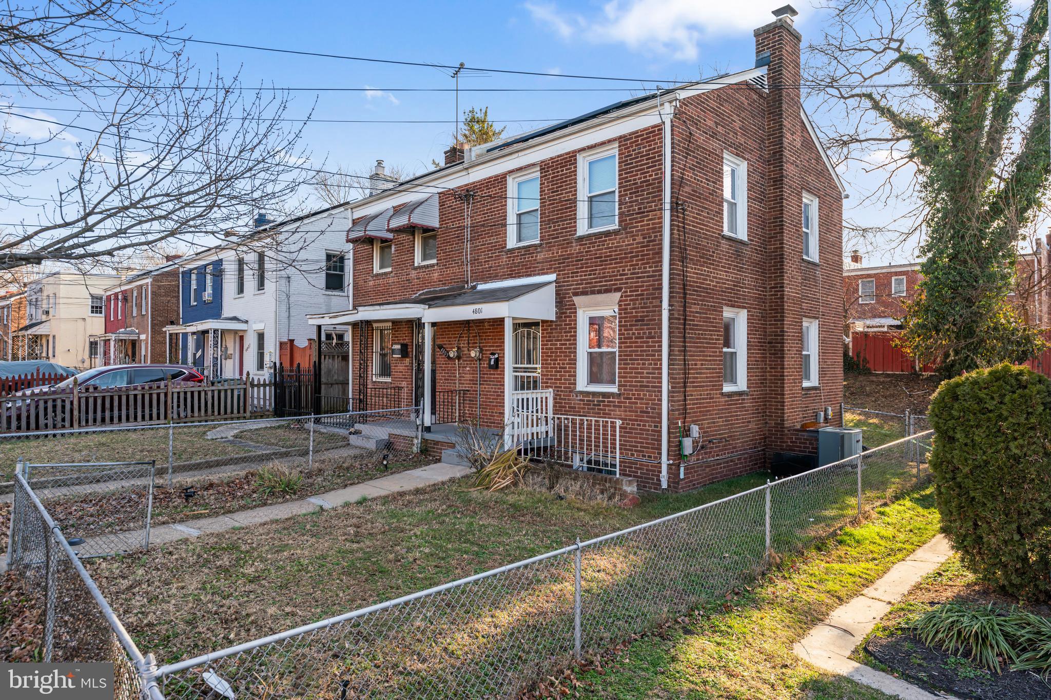 4801 B Street Southeast Washington, DC 20019 - Photo 35 of 43 a view of a brick house with many windows next to a yard