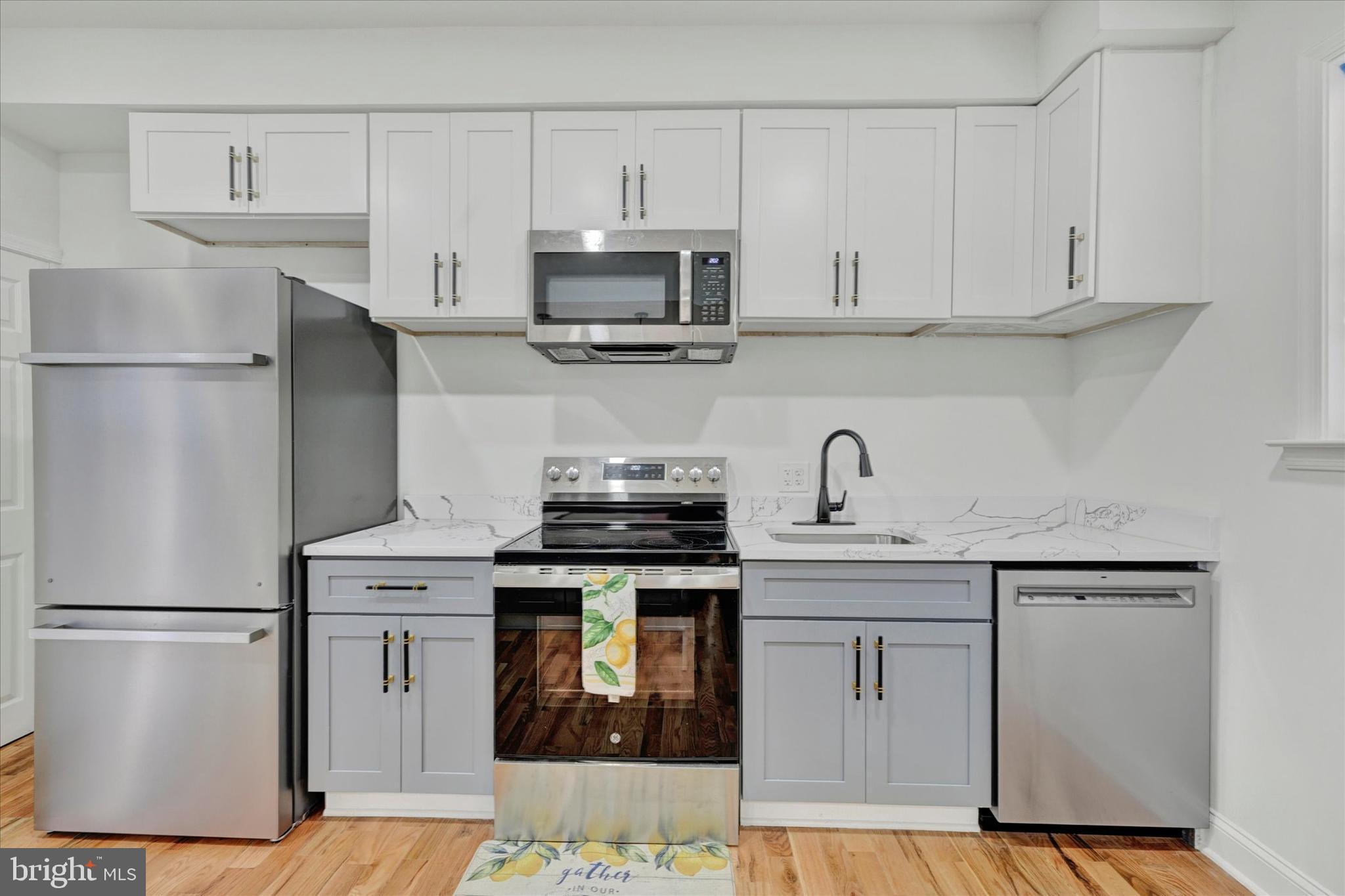 2400 West Lafayette Avenue Baltimore, MD 21216 - Photo 14 of 33 a kitchen with stainless steel appliances granite countertop white cabinets a sink a stove a refrigerator and white cabinets