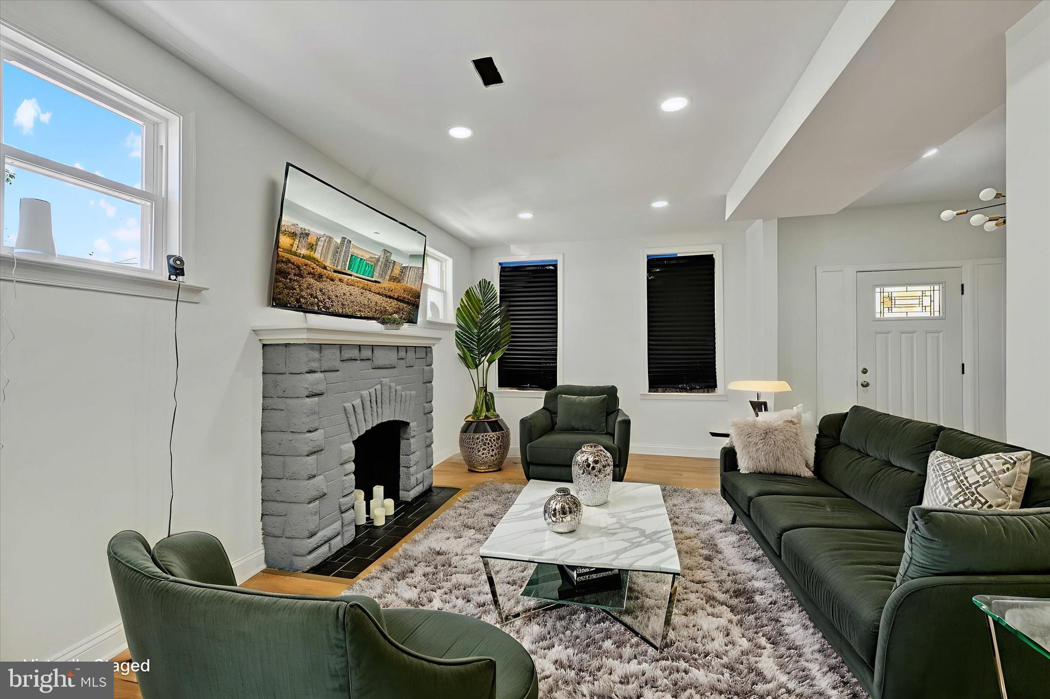 2400 West Lafayette Avenue Baltimore, MD 21216 - Photo 7 of 33 a living room with furniture a fireplace and a flat screen tv