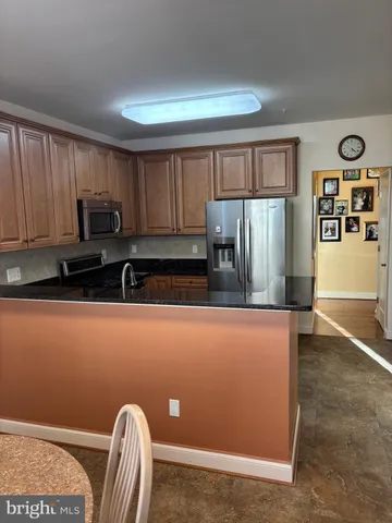 a kitchen with stainless steel appliances granite countertop a refrigerator a stove top oven a sink and dishwasher