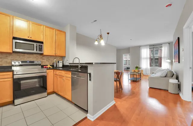 a kitchen with stainless steel appliances granite countertop a refrigerator stove and sink