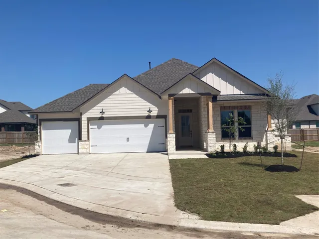 a front view of a house with a yard outdoor seating and garage