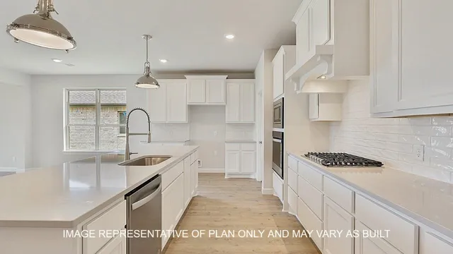 a kitchen with kitchen island stainless steel appliances a sink a stove a refrigerator and cabinets