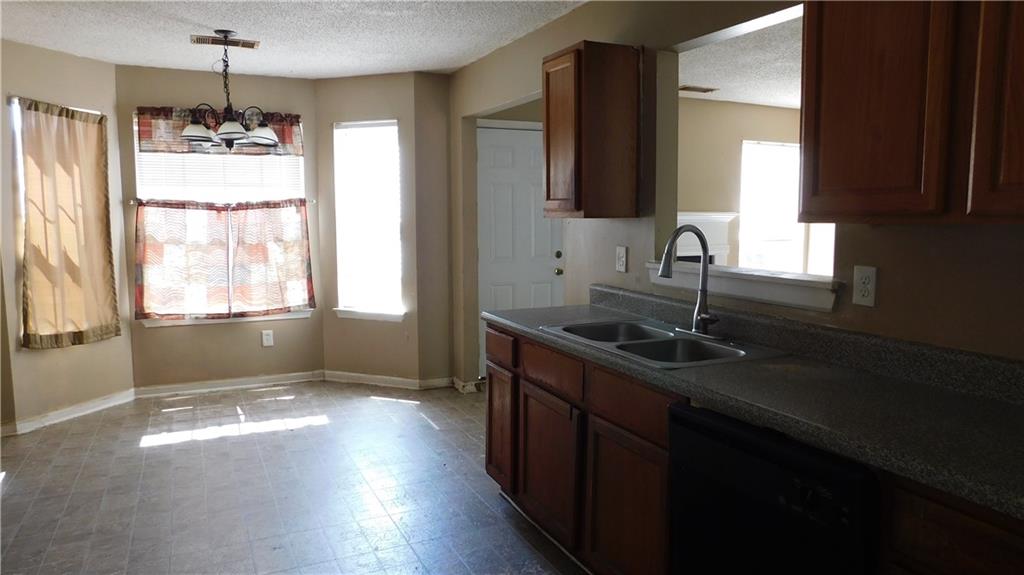 115 Windscape Drive Covington, GA 30016 - Photo 7 of 10 a kitchen with a sink stove and cabinets