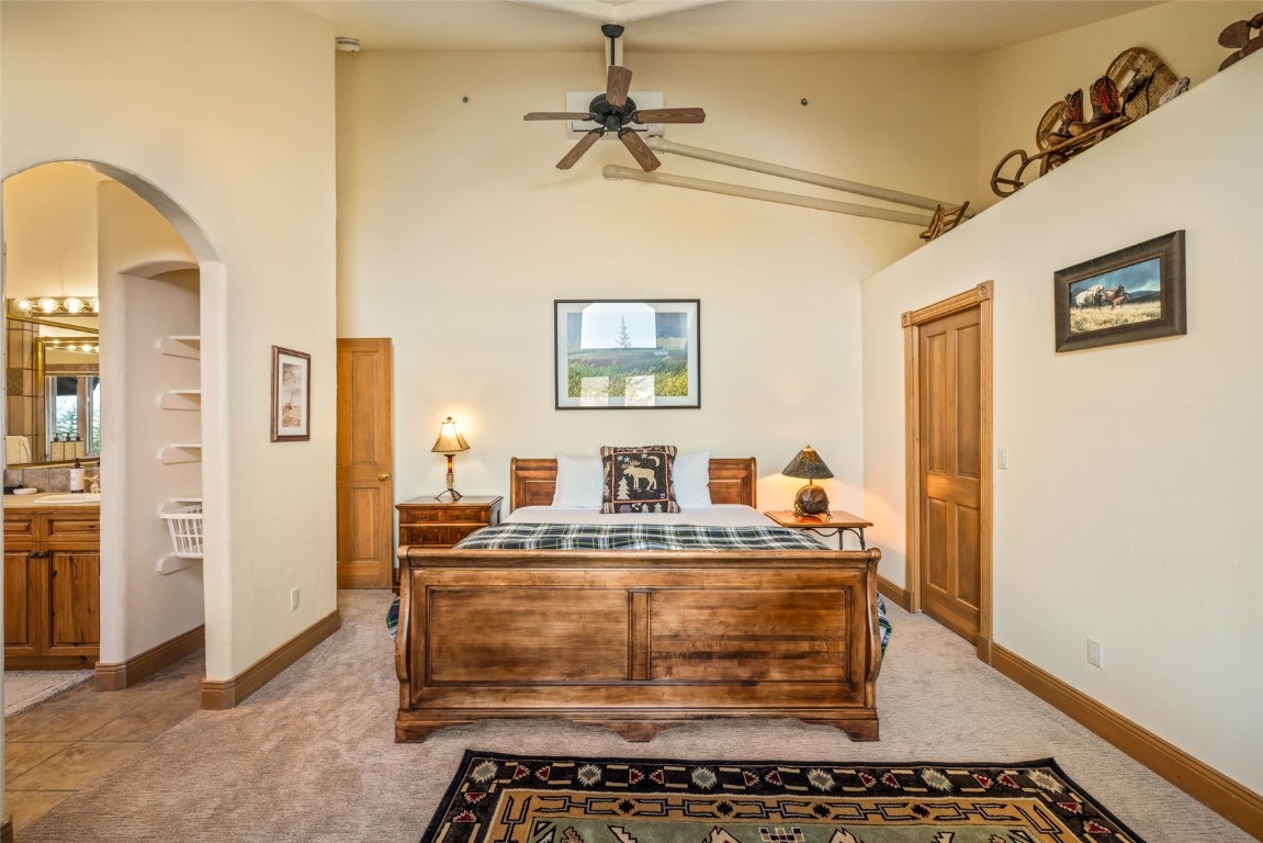 2685 Timber Court, Unit 2 Steamboat Springs, CO 80487 - Photo 12 of 31 Bedroom featuring arched walkways, high vaulted ceiling, baseboards, and light carpet