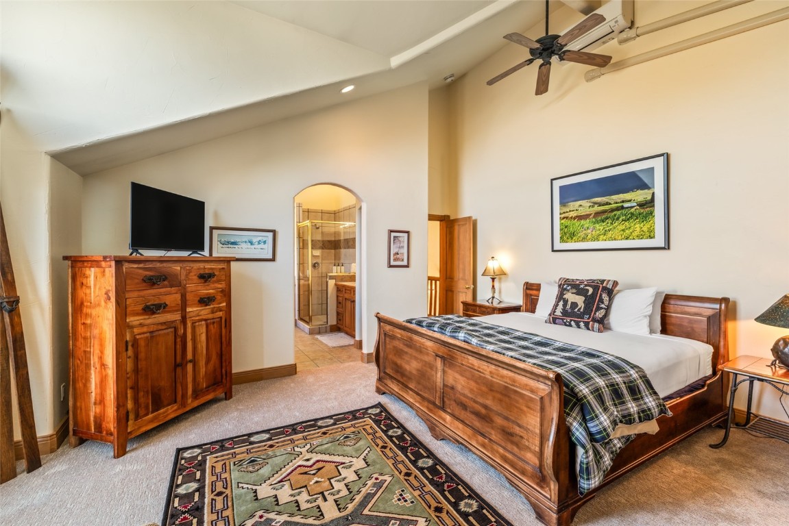 2685 Timber Court, Unit 2 Steamboat Springs, CO 80487 - Photo 14 of 31 Bedroom featuring baseboards, recessed lighting, connected bathroom, high vaulted ceiling, and light colored carpet