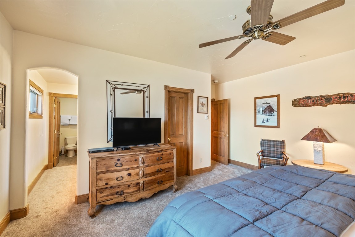 2685 Timber Court, Unit 2 Steamboat Springs, CO 80487 - Photo 23 of 31 Bedroom with baseboards, a ceiling fan, arched walkways, and light carpet