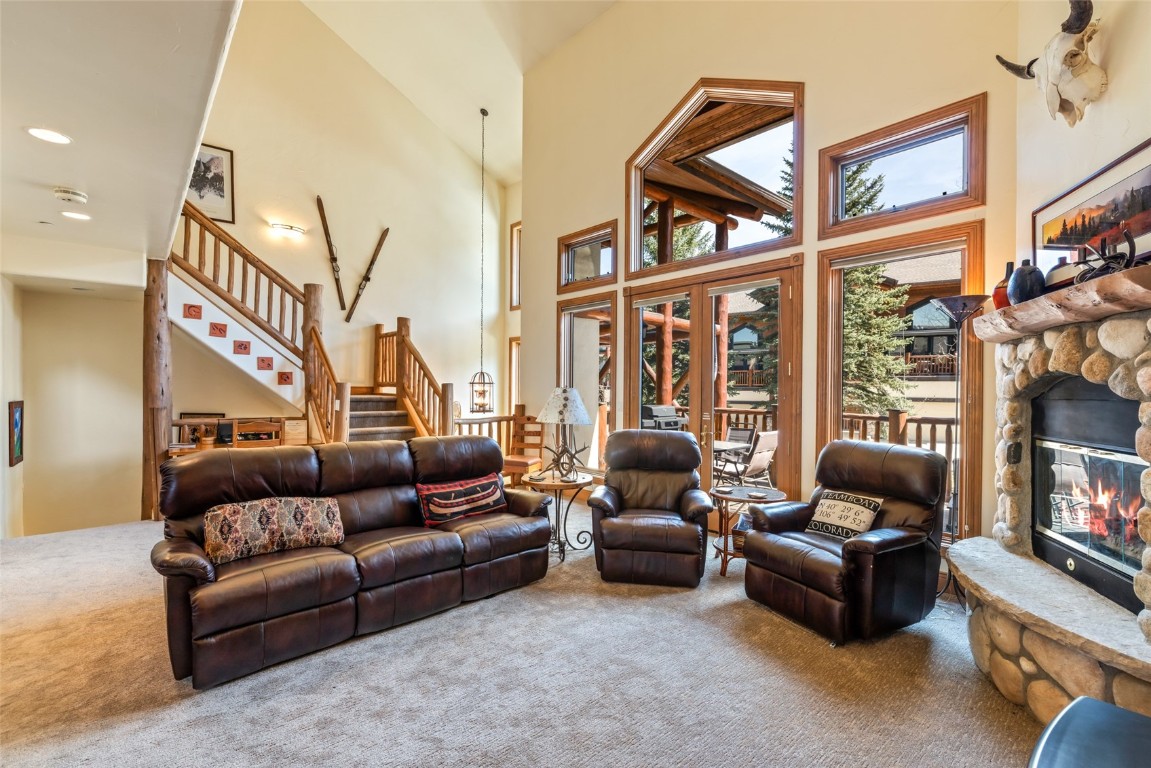2685 Timber Court, Unit 2 Steamboat Springs, CO 80487 - Photo 3 of 31 Carpeted living area with recessed lighting, stairway, a towering ceiling, and a stone fireplace