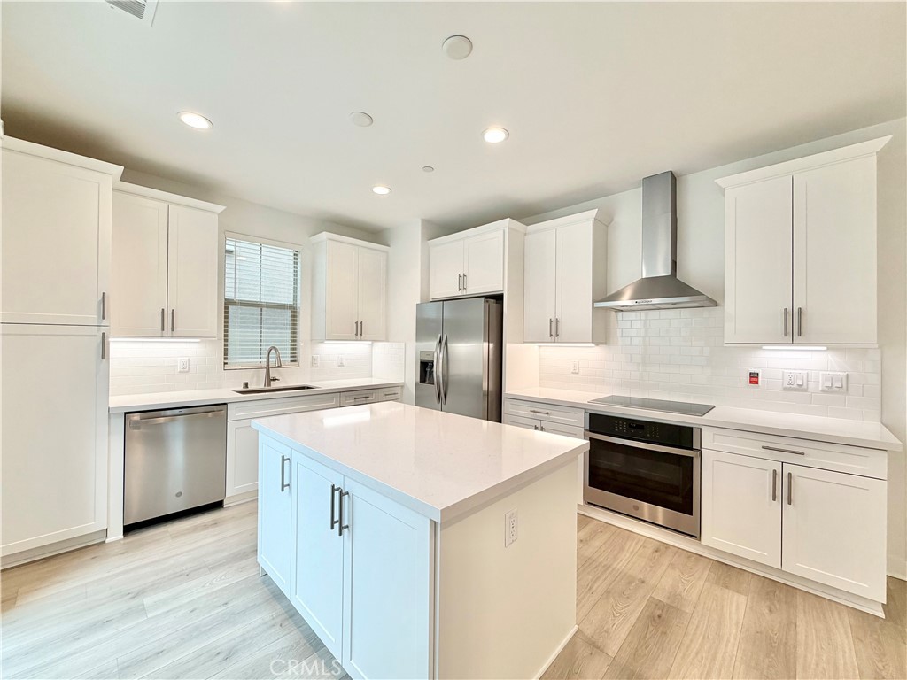 26893 Rubicon Road Menifee, CA 92586 - Photo 8 of 32 a kitchen with white cabinets and stainless steel appliances