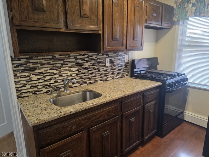604 Freeman Street Lyndhurst, NJ 07071 - Photo 3 of 8 a kitchen with granite countertop a sink and a stove