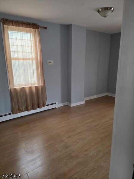 604 Freeman Street Lyndhurst, NJ 07071 - Photo 6 of 8 an empty room with wooden floor and windows