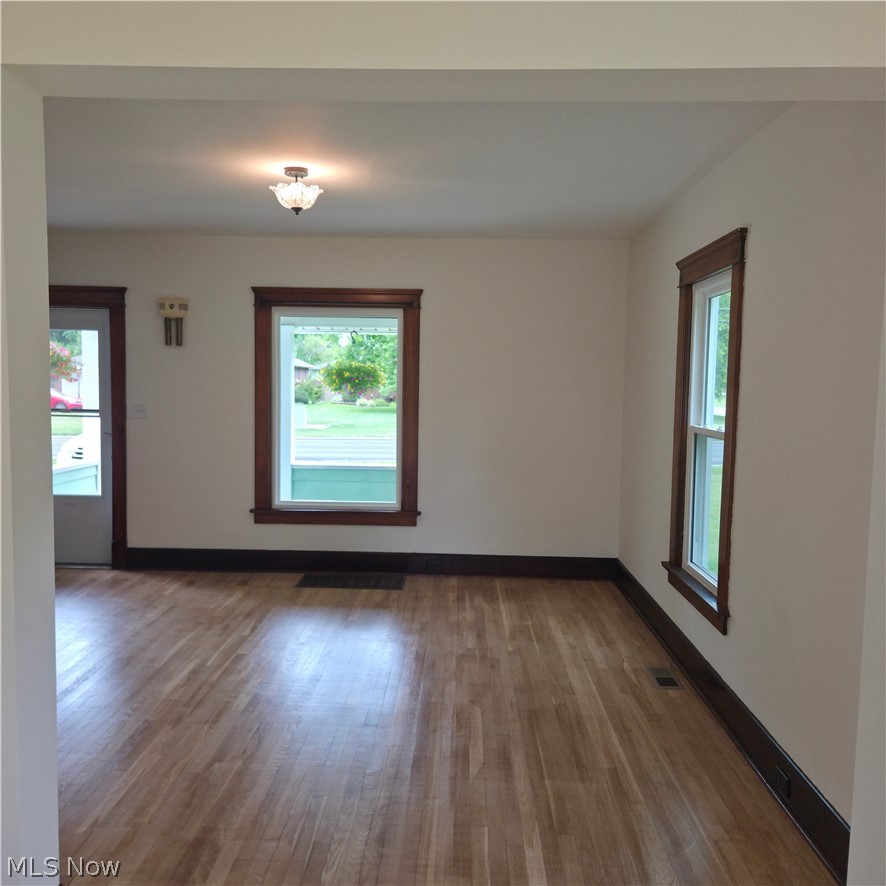 9964 East River Road Elyria, OH 44035 - Photo 9 of 45 Light-filled living room featuring wood-finish flooring, white walls, and dark wood trim