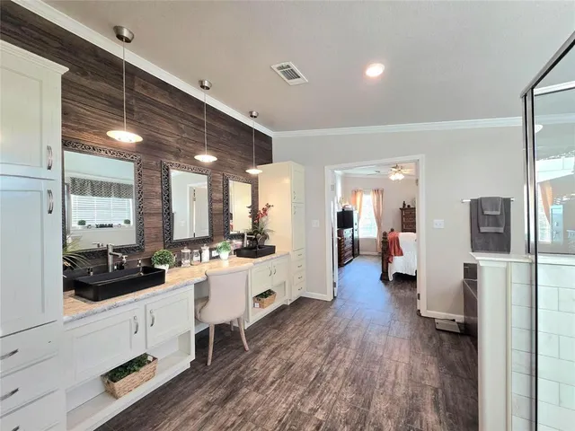 a bathroom with a double vanity sink a mirror a bathtub and shower