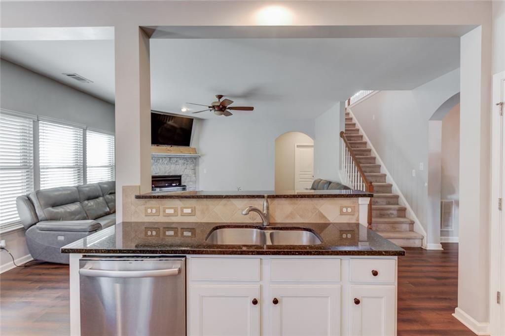 7772 Copper Kettle Way Flowery Branch, GA 30542 - Photo 12 of 43 a kitchen with a sink and a flat screen tv