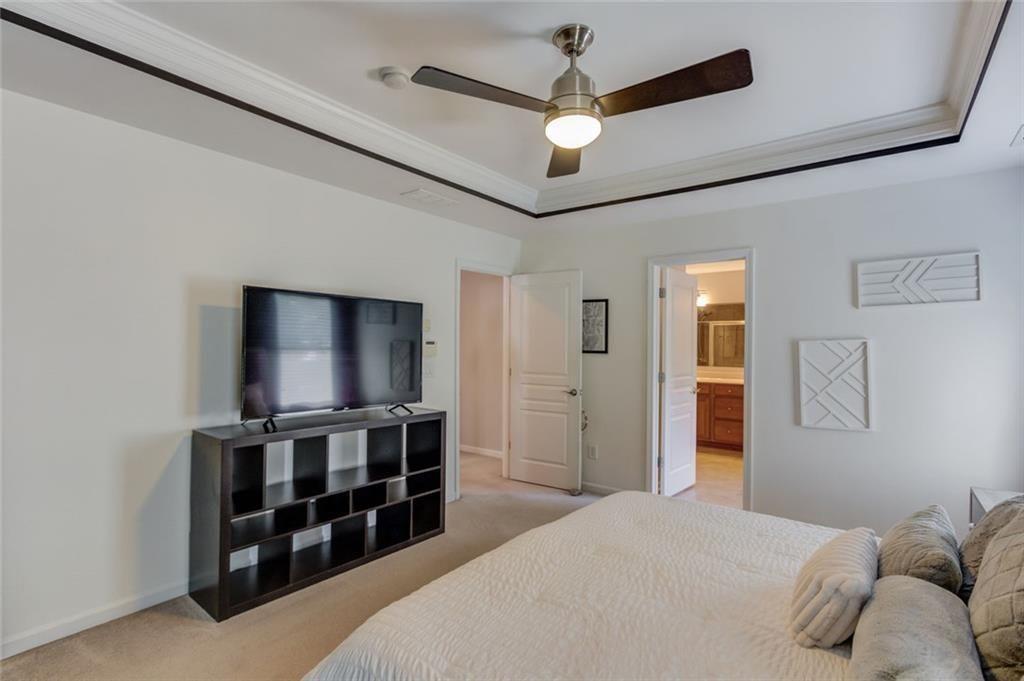7772 Copper Kettle Way Flowery Branch, GA 30542 - Photo 22 of 43 a bedroom with a bed and a flat screen tv