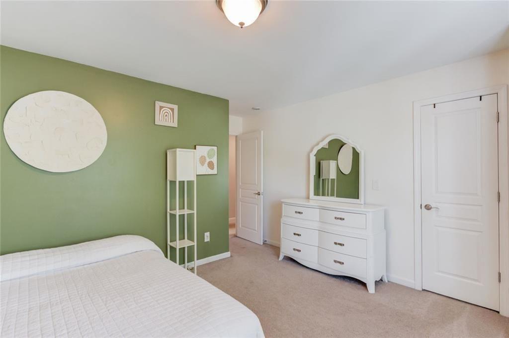 7772 Copper Kettle Way Flowery Branch, GA 30542 - Photo 27 of 43 a bedroom with a bed and a dresser