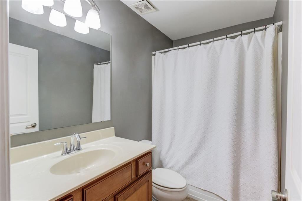 7772 Copper Kettle Way Flowery Branch, GA 30542 - Photo 28 of 43 a bathroom with a sink a toilet and shower curtain