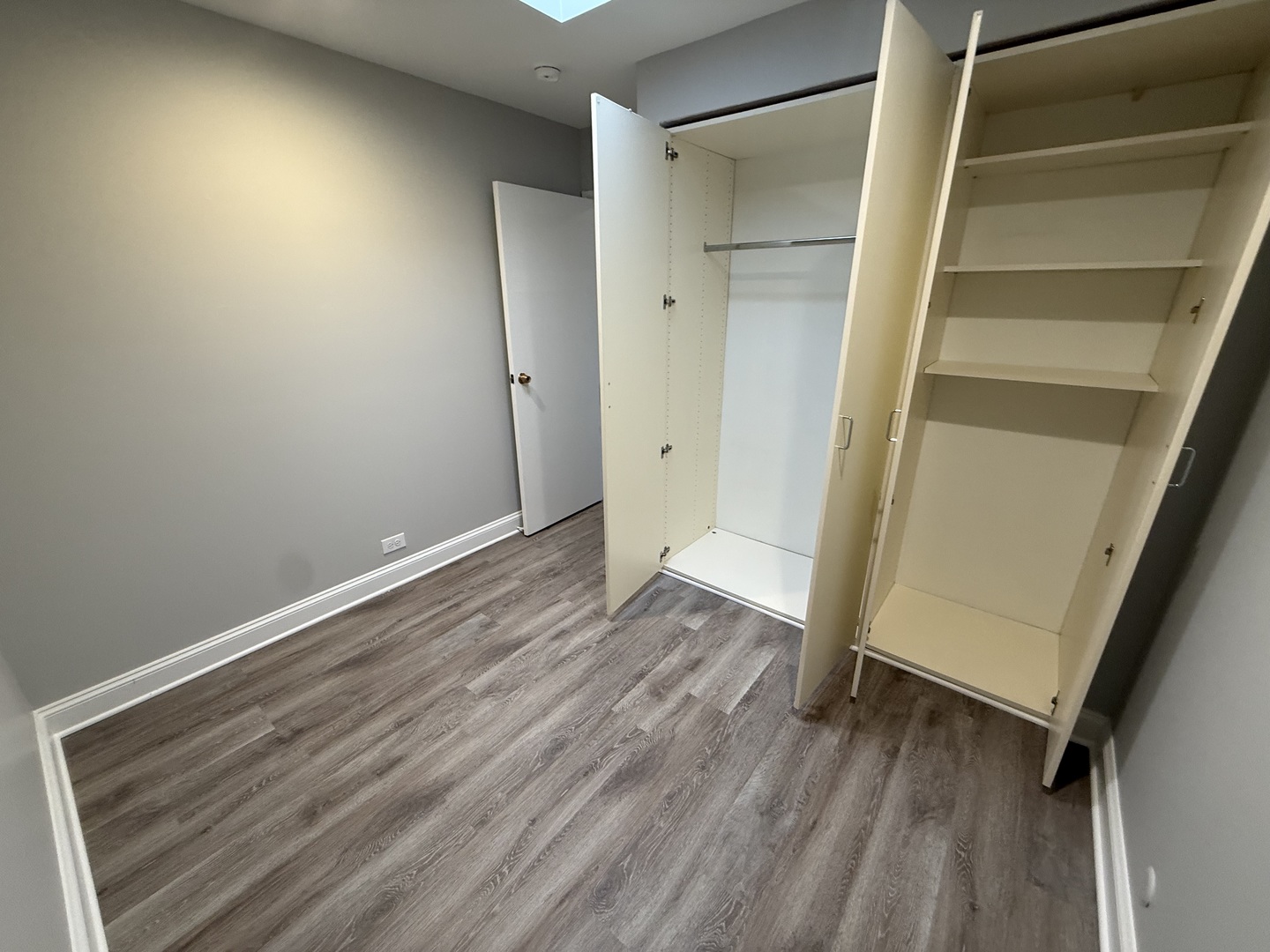 744 West Gordon Terrace, Unit 305 Chicago, IL 60613 - Photo 11 of 12 a view of an empty room with wooden floor and a window