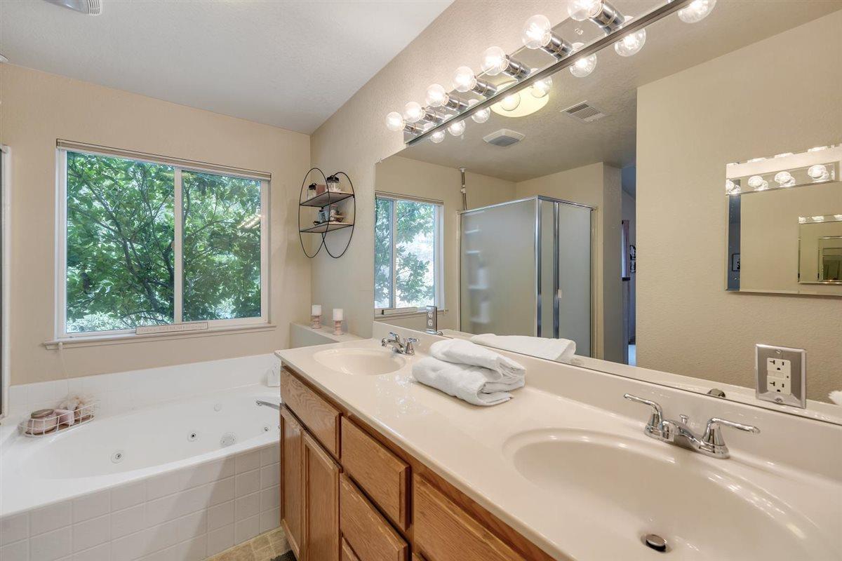 2441 Quail Hill Road, Unit 262 Copperopolis, CA 95228 - Photo 34 of 90 a bathroom with a tub a double vanity sink a large mirror and shower