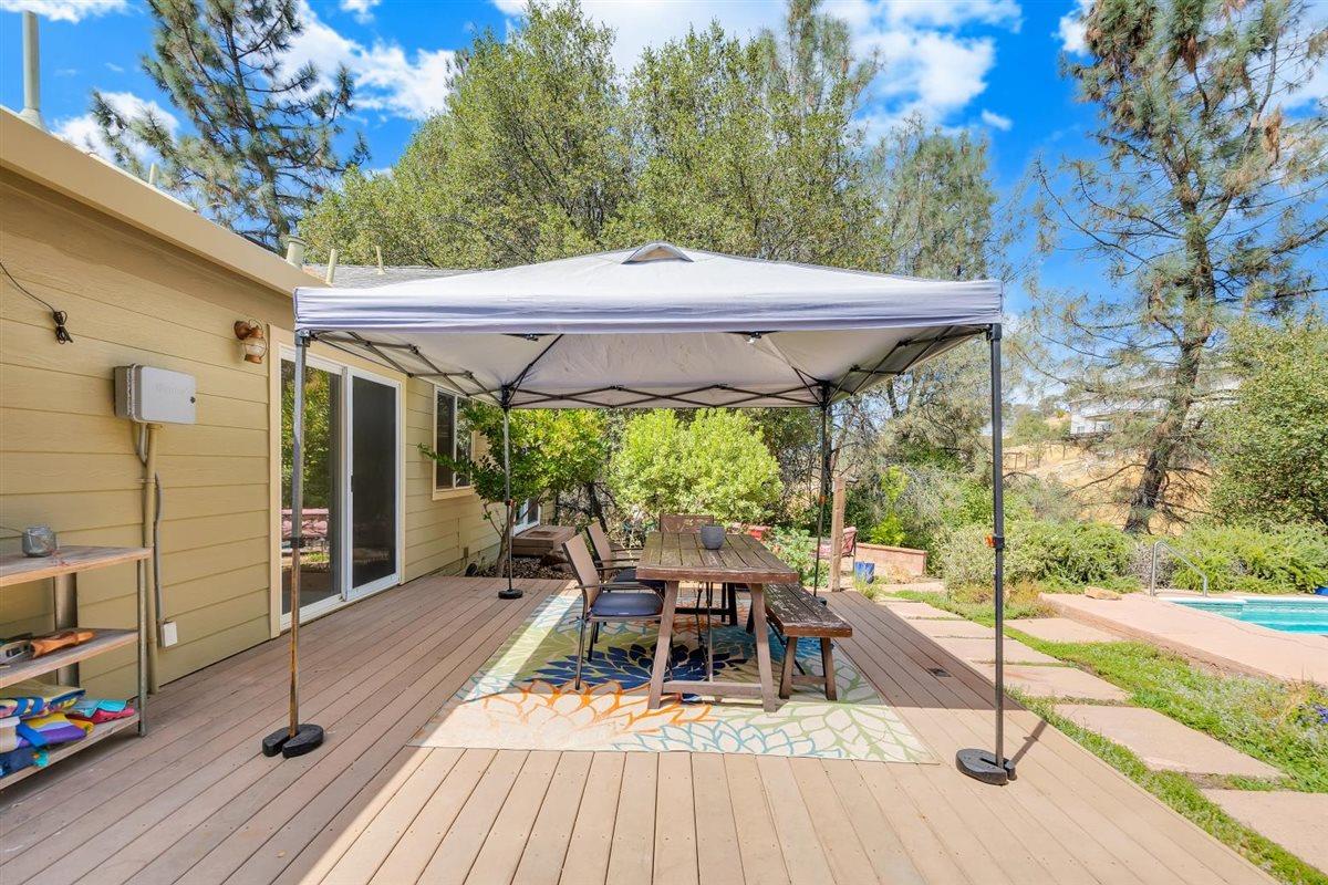 2441 Quail Hill Road, Unit 262 Copperopolis, CA 95228 - Photo 47 of 90 a view of a patio with table and chairs under an umbrella with wooden floor