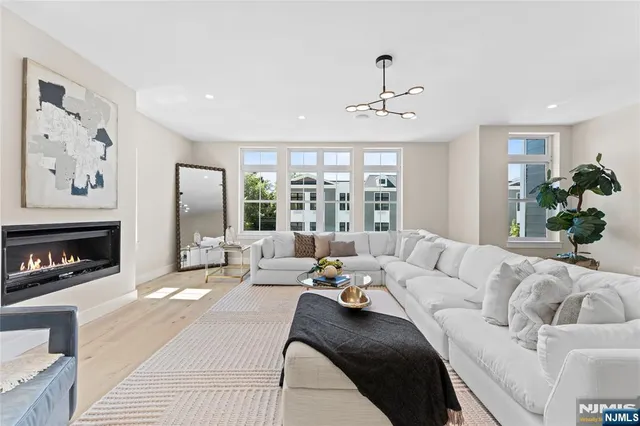 a living room with furniture fireplace and a large window