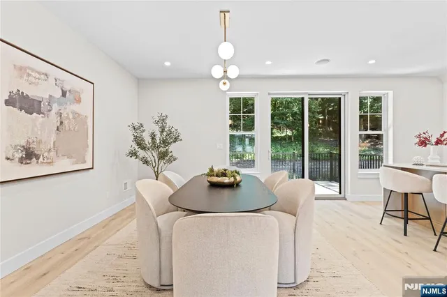 a dining room with furniture and large windows
