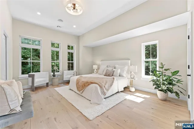 a spacious bedroom with a large bed and a potted plant