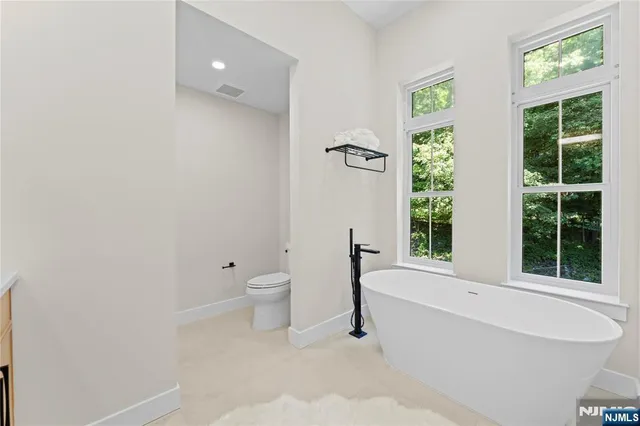 a spacious bathroom with a bathtub and a toilet