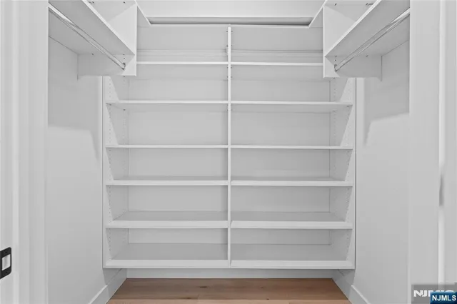 a view of walk in closet with empty racks