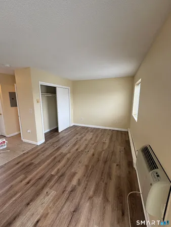 a view of an empty room with wooden floor