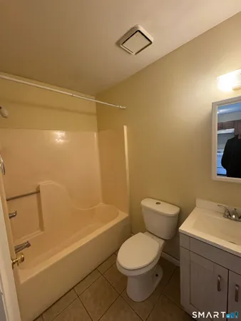 a white toilet sitting next to a bath tub