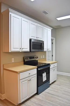 a kitchen with stainless steel appliances granite countertop a stove a sink and white cabinets