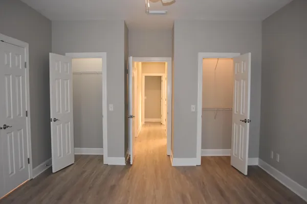 a view of hallway with bathroom and wooden floor