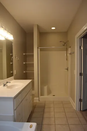 a bathroom with a sink mirror and shower